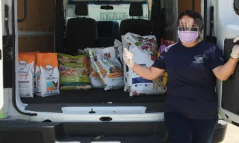 Pets for Life staff member with a van full of supplies