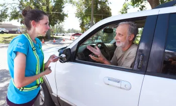 An HSUS volunteer assisting a visitor at the pet supply distribution center in Florida.