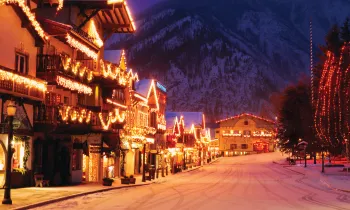 A snow covered street filled with lights at night.