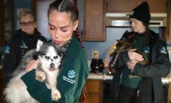 A staffer holds a dog at a rescue