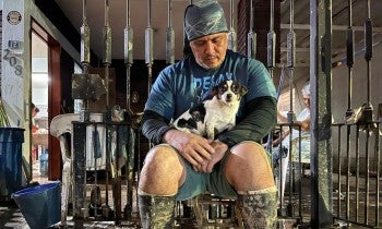 A man sitting with a dog in his lap