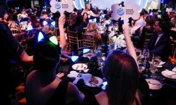 a group of people sitting at a table holding signs