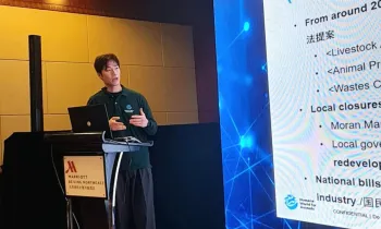 Man speaking at podium in front of a projector