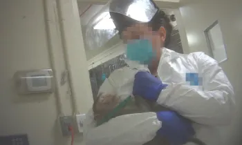 Monkey held by unidentified laboratory attendant.