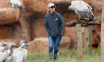 A woman, walking outside at a vulture conservation center. 