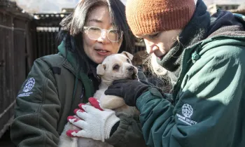 JungAh Chae and Lola Webber of HSI, hold a puppy at a dog meat farm