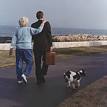 H.W. Bush and Barbara walk with their dogs along the shore