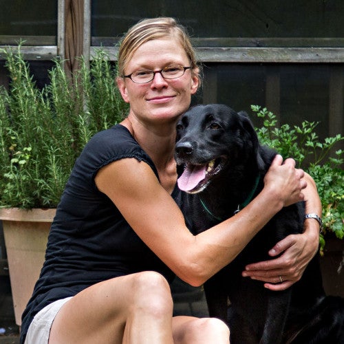 Woman and her black dog on back porch of their home