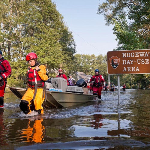 Animal rescue team carries rescued animals in a boat through flooded waters following Hurricane Harvey response