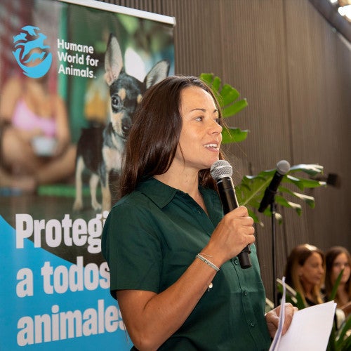 A woman in Chile talking into a microphone at an event