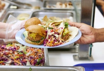 Plant-based food on a plate in a cafeteria.