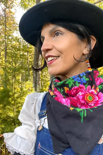 Woman outside, in a natural setting wearing a hat