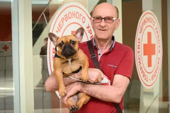 A man holds his dog at the Ukrainian Red Cross