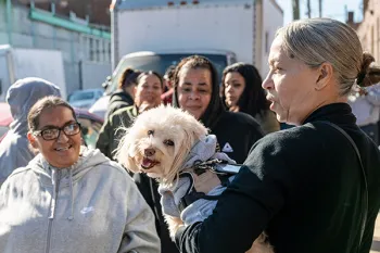 People line up with their pets waiting to get pet food and supplies