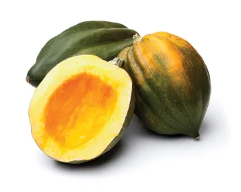 Three acorn squash, one cut in half, isolated on a white background