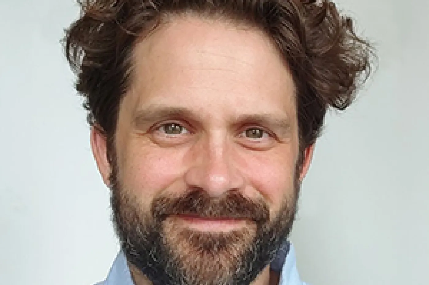 headshot of a smiling man with dark hair