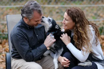 Susan and Doug with their dog Emma in the backyard at their home.