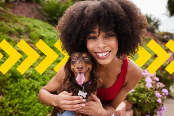 Woman smiling with her dog in her lap. Taking Action for Animals 2023.