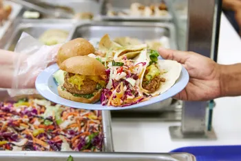 Plant-based food on a plate in a cafeteria.