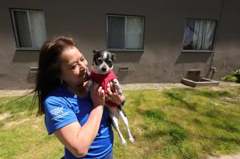 Woman holds and greets a dog