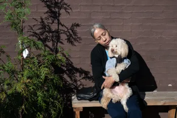 Woman holding a dog outside