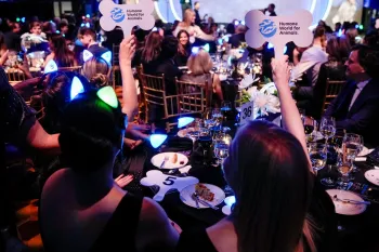 a group of people sitting at a table holding signs