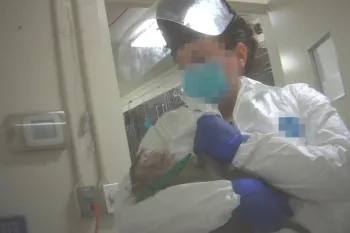 Monkey held by unidentified laboratory attendant.