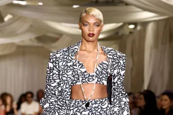 a fashion runway where a model is wearing a black and white ensemble