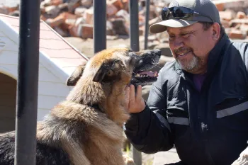 Man and dog outside in the rubble after Child wildfires.