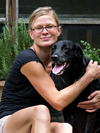 Woman and her black dog on back porch of their home