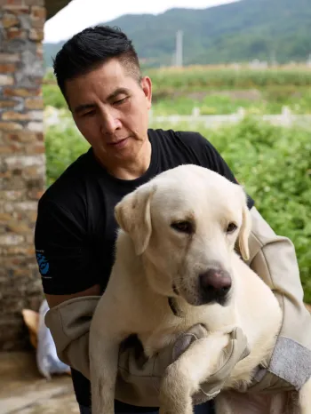 A person holding a large cream-colored dog in their arms