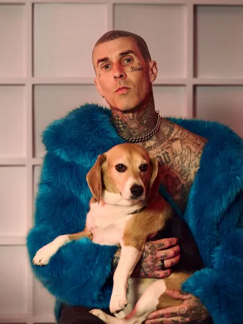 Musician Travis Barker holding a beagle