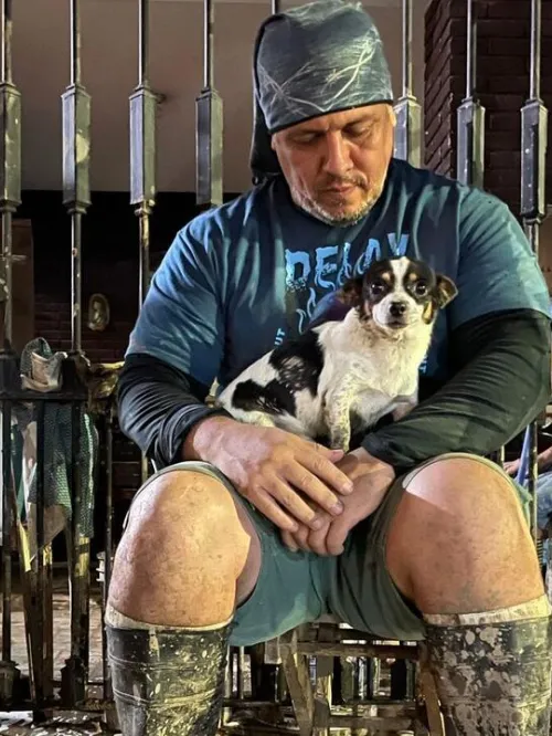 A man sitting with a dog in his lap