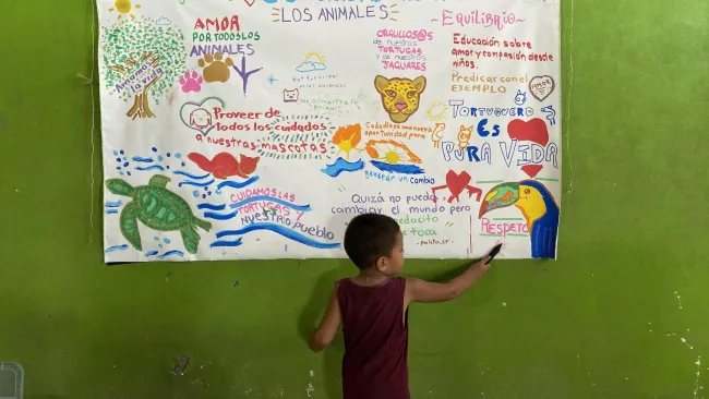 A child points to an informational poster