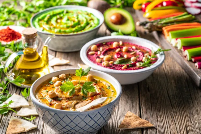 Various vegan dishes set on a table with other vegetables