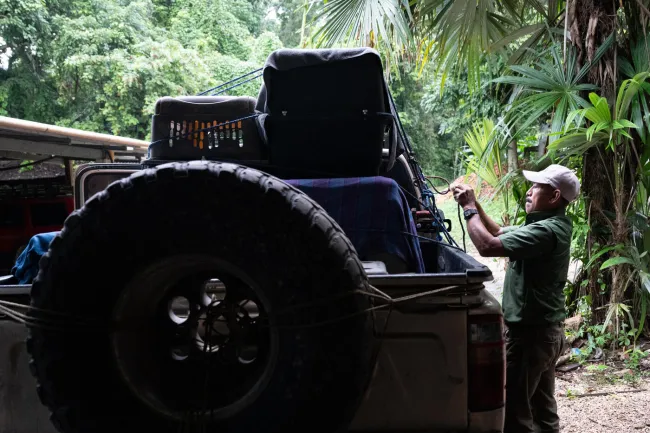 A man ties crates and boxes to the bed of a pickup truck in Petén Guatemala