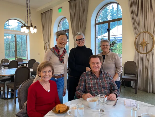 Svanee and Russ Castner pose with three Humane World team members for a photo around a breakfast table.
