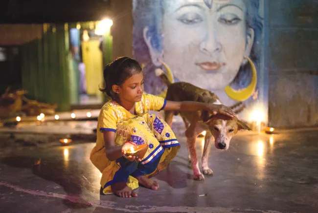 A Bangladeshi Hindu girl holds an oil lamp during the 'Deep Utsav or Light festival' ahead of the Diwali festival in Dhaka, Bangladesh