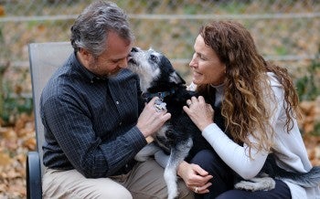 Susan and Doug with their dog Emma in the backyard at their home.