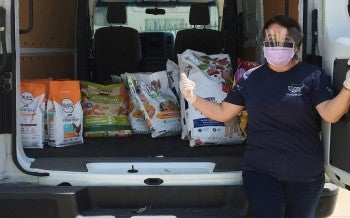 Pets for Life staff member with a van full of supplies