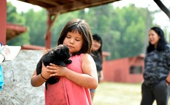  girl holds a puppy