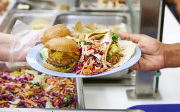 Plant-based food on a plate in a cafeteria.