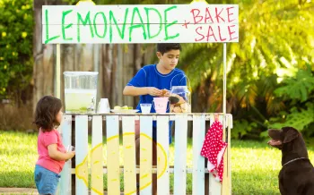 Children and dog running a lemonade stand and bake sale.
