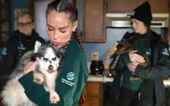 A staffer holds a dog at a rescue