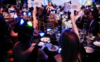 a group of people sitting at a table holding signs