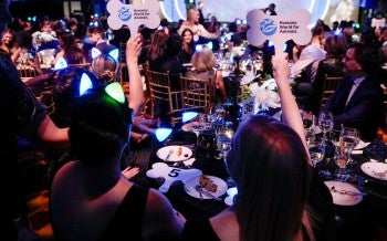 a group of people sitting at a table holding signs
