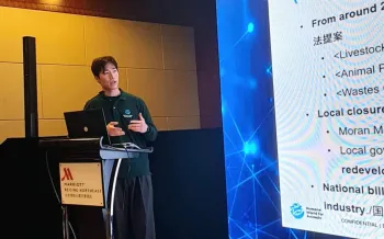 Man speaking at podium in front of a projector