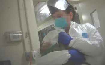 Monkey held by unidentified laboratory attendant.