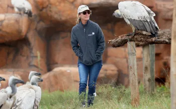 A woman, walking outside at a vulture conservation center. 
