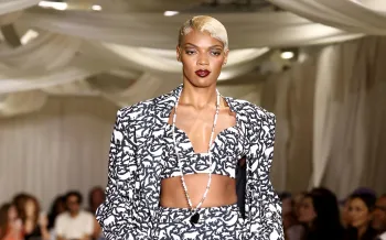 a fashion runway where a model is wearing a black and white ensemble